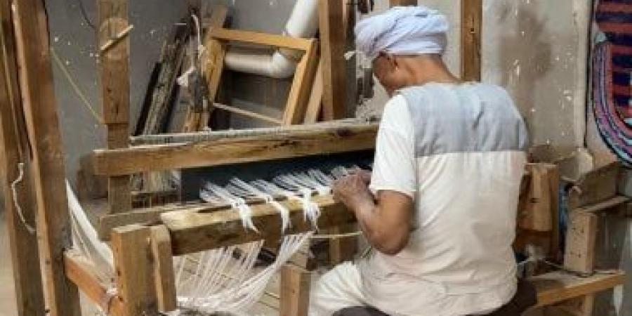 إرث لا يموت.. العم أحمد يدرب رجال وسيدات مجانا لصناعة الشال اليدوى بقنا.. صور